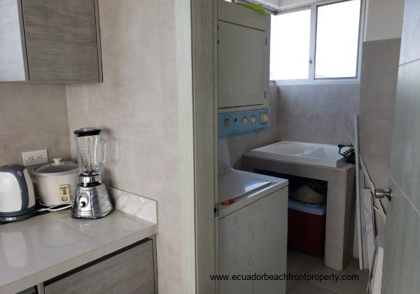 Laundry room off the kitchen equipped with washer, dryer, utility sink and water heater