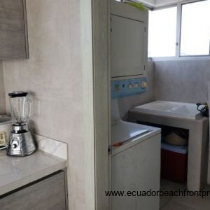 Laundry room off the kitchen equipped with washer, dryer, utility sink and water heater