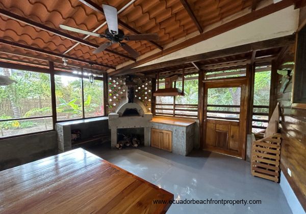 indoor patio with wood fired oven, counter prep space and hood vent 