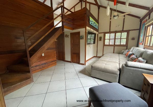 living room with stairs to large loft bedroom 