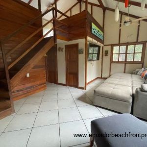 living room with stairs to large loft bedroom 