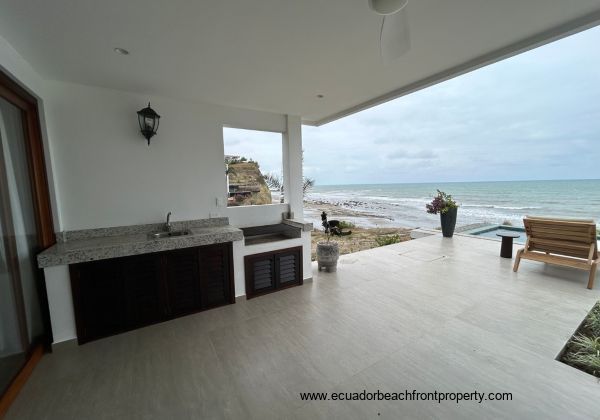 Kitchen opens to an expansive oceanfront patio with outdoor kitchen space