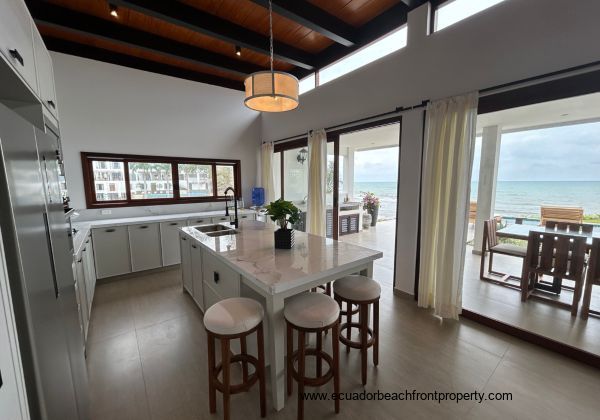 Kitchen opens to an expansive oceanfront patio with outdoor kitchen space