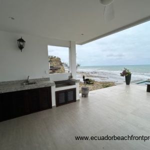 Kitchen opens to an expansive oceanfront patio with outdoor kitchen space